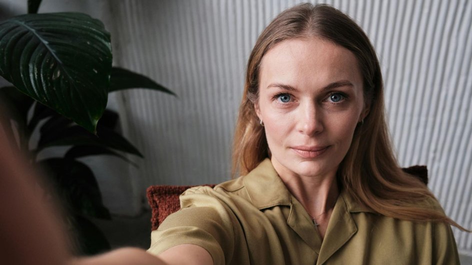 Девушка делает селфи в фотостудии и смотрит в камеру Девушка делает селфи в фотостудии и смотрит в камеру